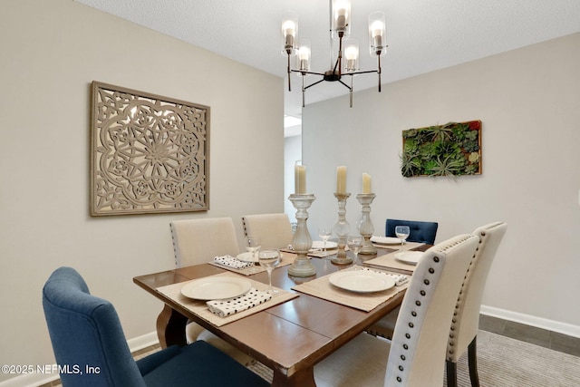 dining room with a chandelier and a textured ceiling