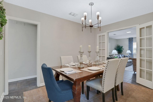 tiled dining room featuring a chandelier