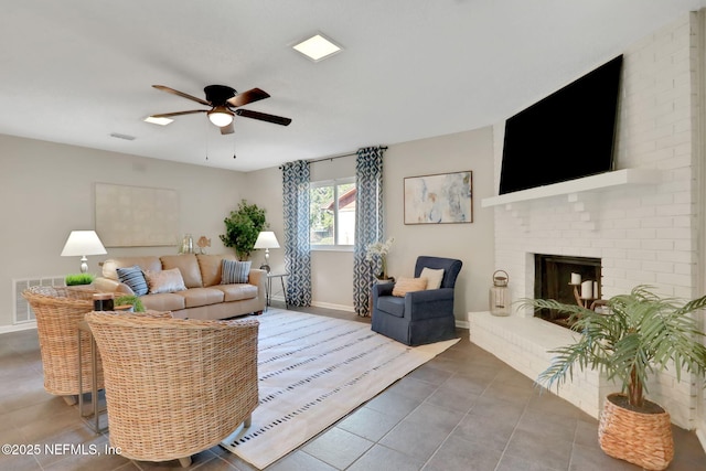 living room featuring a brick fireplace, tile patterned floors, and ceiling fan