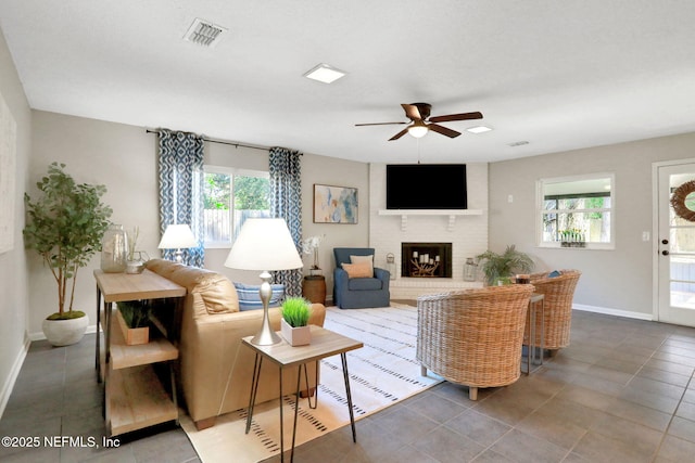 living room featuring a fireplace, tile patterned floors, and ceiling fan