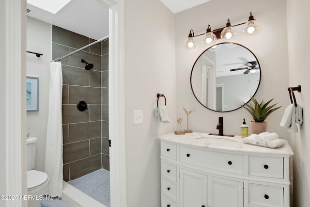 bathroom with toilet, a shower with curtain, a skylight, vanity, and ceiling fan