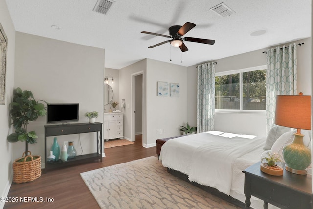 bedroom featuring ceiling fan, dark hardwood / wood-style floors, and a textured ceiling