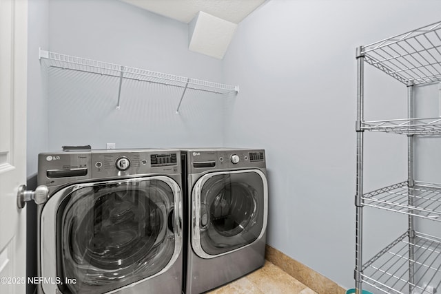 laundry area with tile patterned flooring, laundry area, independent washer and dryer, and baseboards