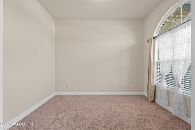 carpeted spare room with baseboards