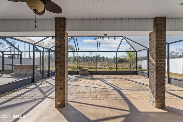 view of patio featuring glass enclosure and ceiling fan