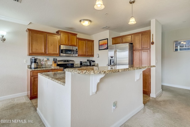 kitchen featuring a breakfast bar area, light stone counters, an island with sink, pendant lighting, and stainless steel appliances