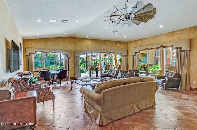 living room featuring ceiling fan, lofted ceiling, light tile patterned floors, and a textured ceiling