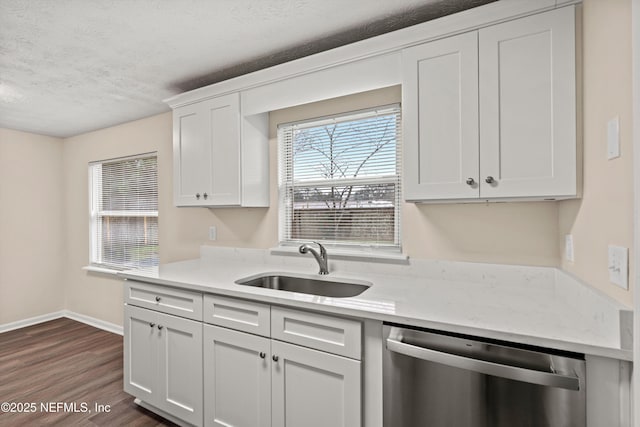 kitchen with dishwasher, plenty of natural light, a sink, and white cabinetry