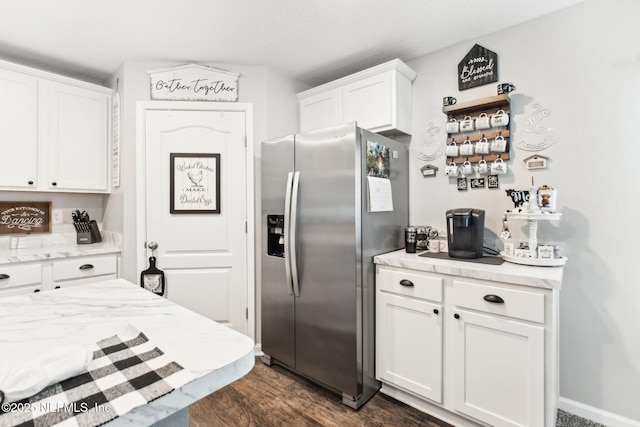 kitchen featuring stainless steel refrigerator with ice dispenser, dark wood-type flooring, and white cabinets