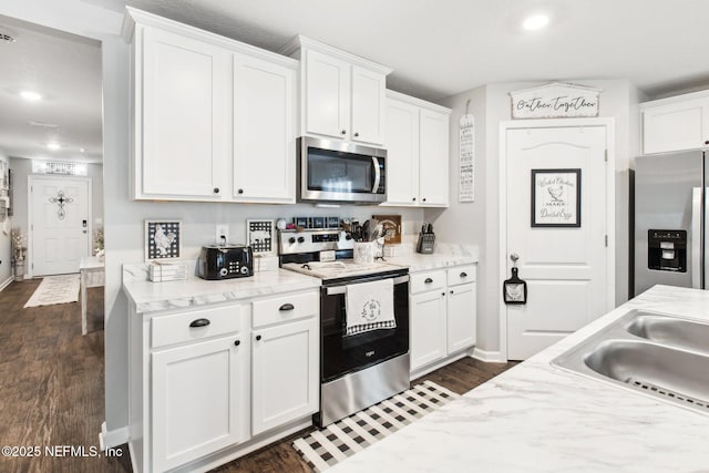 kitchen featuring sink, white cabinetry, stainless steel appliances, light stone countertops, and dark hardwood / wood-style flooring