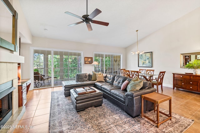 living room with a tile fireplace, vaulted ceiling, a wealth of natural light, and tile patterned floors