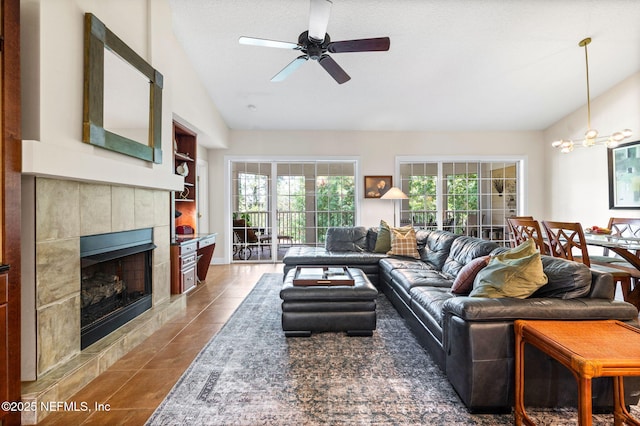 tiled living room featuring ceiling fan, lofted ceiling, and a fireplace