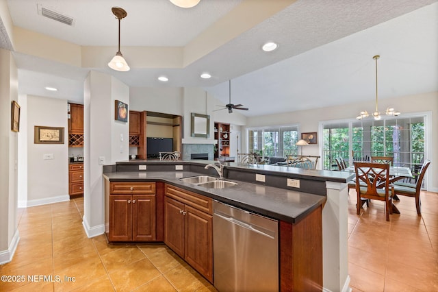 kitchen with hanging light fixtures, dishwasher, sink, and light tile patterned floors