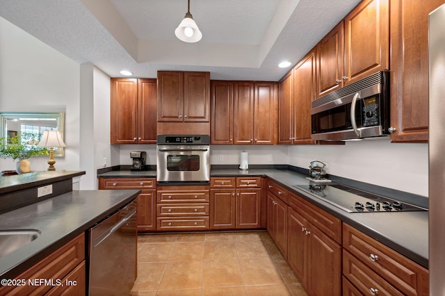 kitchen featuring light tile patterned flooring, hanging light fixtures, a textured ceiling, appliances with stainless steel finishes, and a raised ceiling