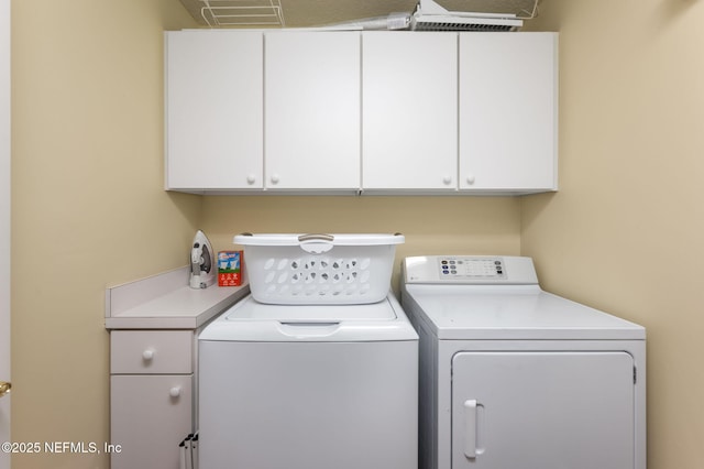 laundry area featuring washing machine and dryer and cabinets