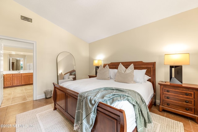 bedroom with vaulted ceiling, connected bathroom, and light tile patterned flooring