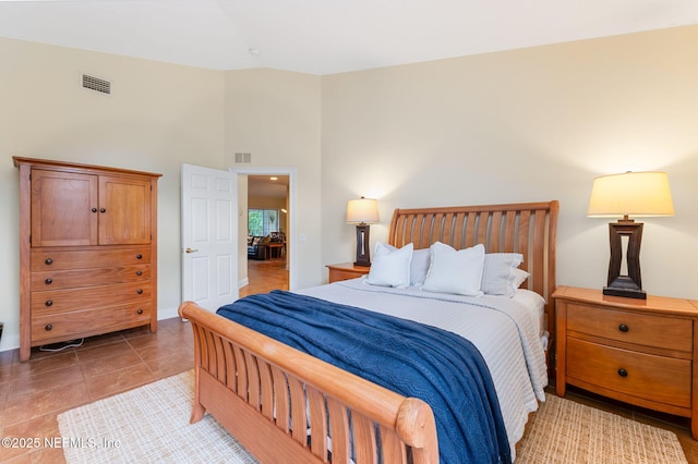 bedroom with light tile patterned floors and high vaulted ceiling