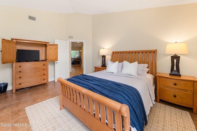 bedroom with lofted ceiling and tile patterned floors