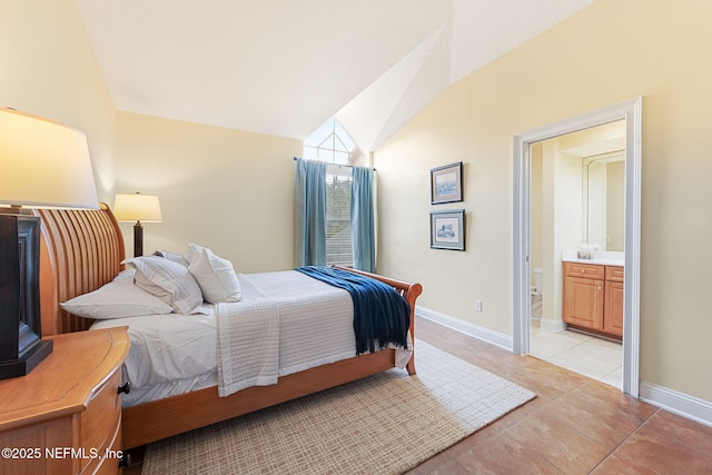 bedroom with lofted ceiling, connected bathroom, and light tile patterned floors