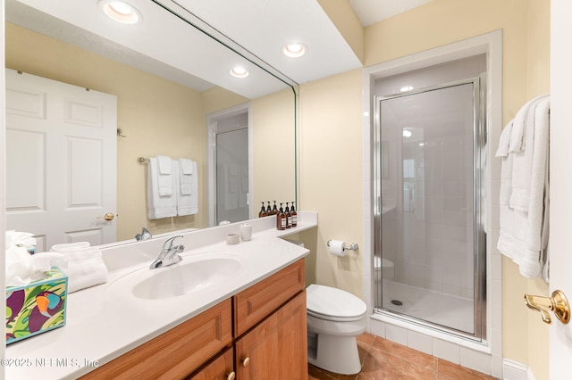 bathroom with toilet, vanity, tile patterned floors, and walk in shower