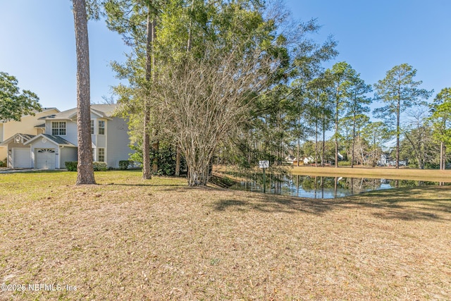 view of yard with a water view and a garage