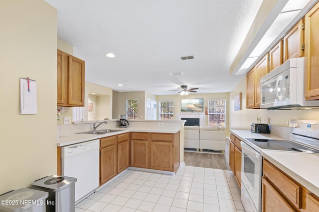 kitchen featuring sink, white appliances, light tile patterned floors, kitchen peninsula, and ceiling fan