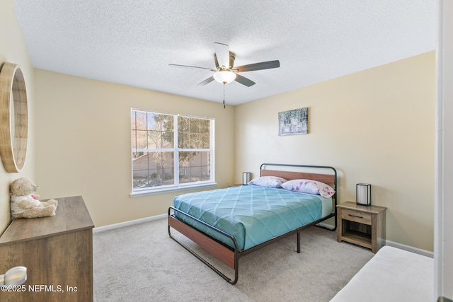 carpeted bedroom with ceiling fan and a textured ceiling