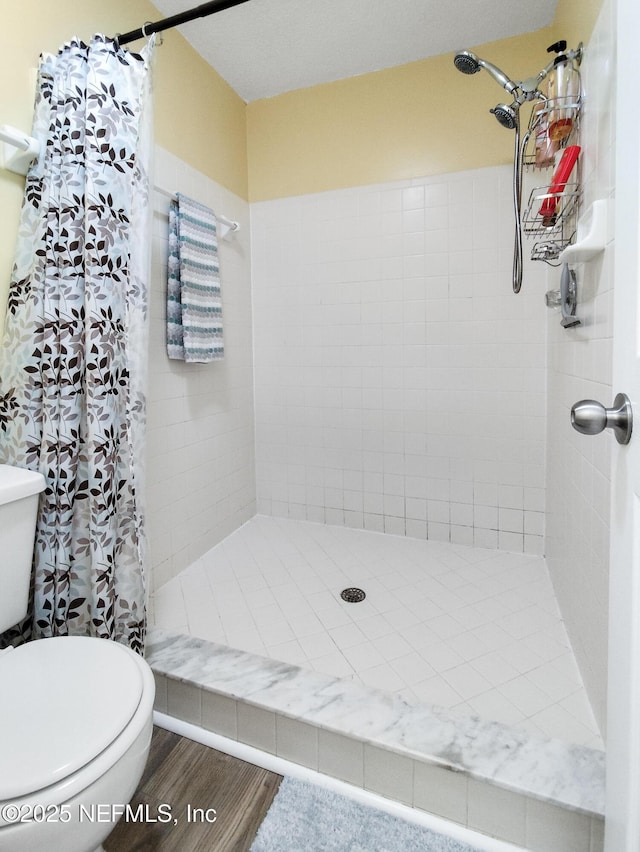 bathroom featuring hardwood / wood-style flooring, curtained shower, and toilet