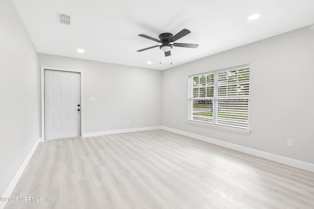 empty room featuring light wood-style floors, recessed lighting, visible vents, and baseboards