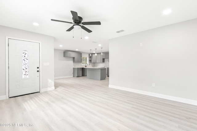 unfurnished living room with recessed lighting, visible vents, ceiling fan, light wood-type flooring, and baseboards