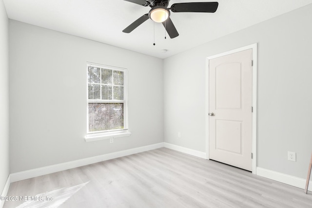 spare room with light wood-style flooring, baseboards, and a ceiling fan