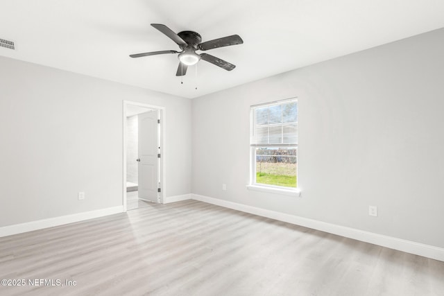 empty room featuring baseboards, visible vents, and light wood-style floors