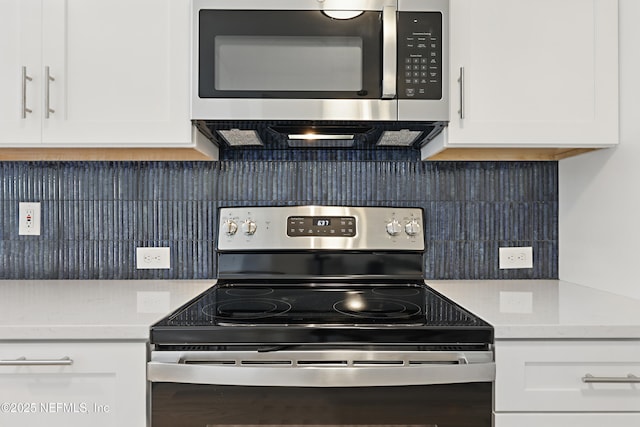 kitchen featuring stainless steel appliances, white cabinets, and tasteful backsplash