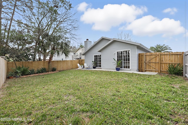 rear view of house with a patio area, a gate, a fenced backyard, and a lawn