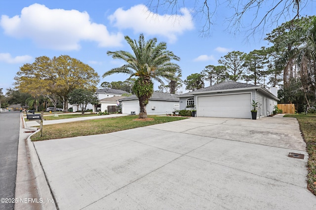 view of front of house featuring an attached garage, concrete driveway, and a front yard