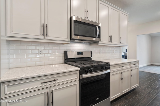 kitchen featuring stainless steel appliances, light stone counters, decorative backsplash, dark hardwood / wood-style flooring, and white cabinetry