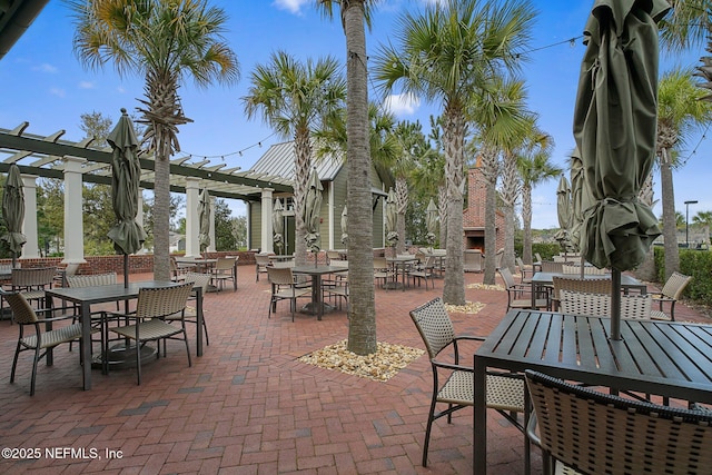 view of patio with exterior fireplace and a pergola