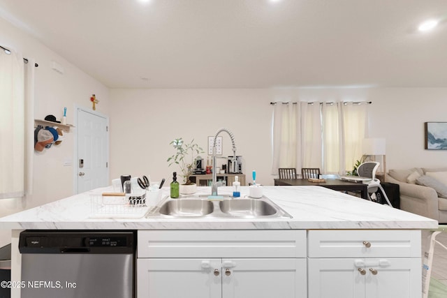 kitchen with white cabinetry, stainless steel dishwasher, sink, and a kitchen island with sink