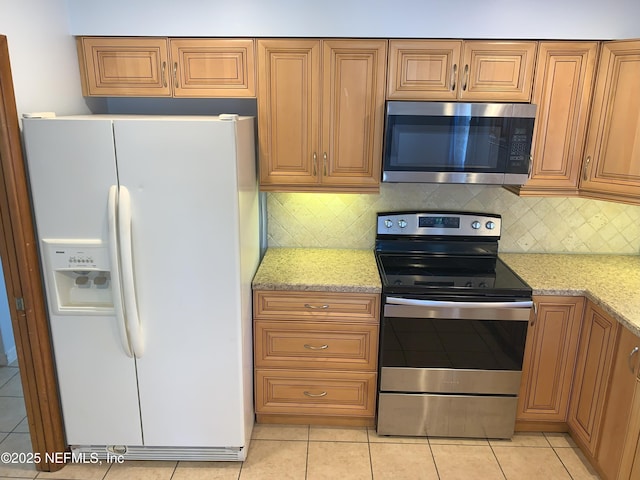 kitchen with backsplash, stainless steel appliances, light stone countertops, and light tile patterned floors