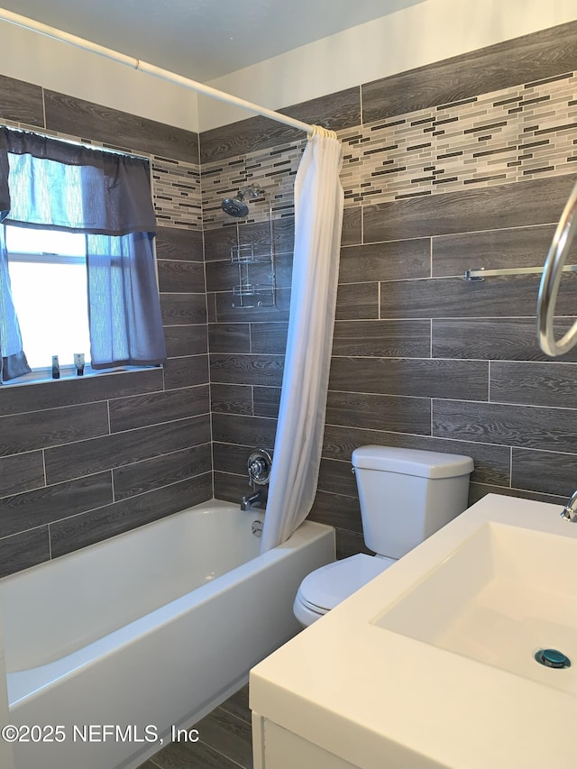 full bathroom featuring toilet, sink, tile walls, and shower / bath combo