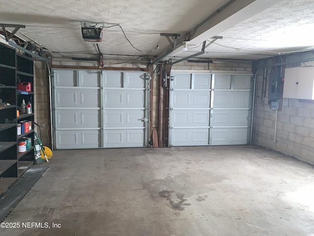 garage with a garage door opener and electric panel