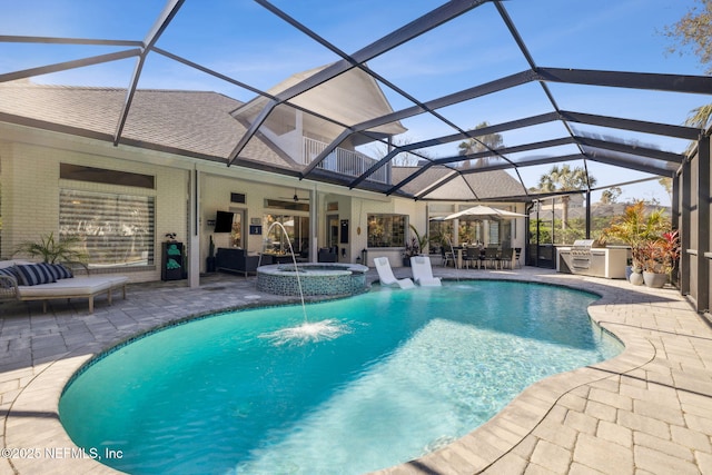 pool featuring a patio area, glass enclosure, exterior kitchen, and an in ground hot tub