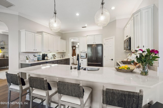 kitchen with light countertops, high quality fridge, stainless steel microwave, and white cabinets