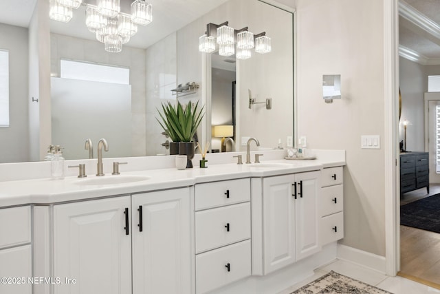 ensuite bathroom with double vanity, baseboards, a sink, and ensuite bathroom