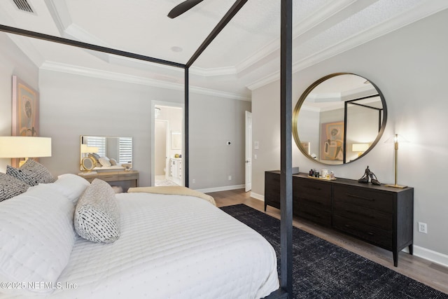 bedroom with baseboards, wood finished floors, visible vents, and crown molding