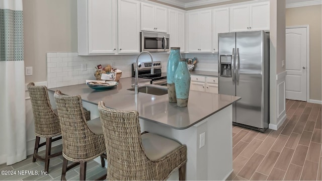 kitchen featuring white cabinetry, a peninsula, backsplash, and stainless steel appliances