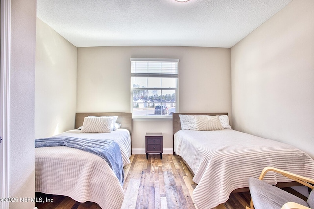 bedroom with hardwood / wood-style floors and a textured ceiling