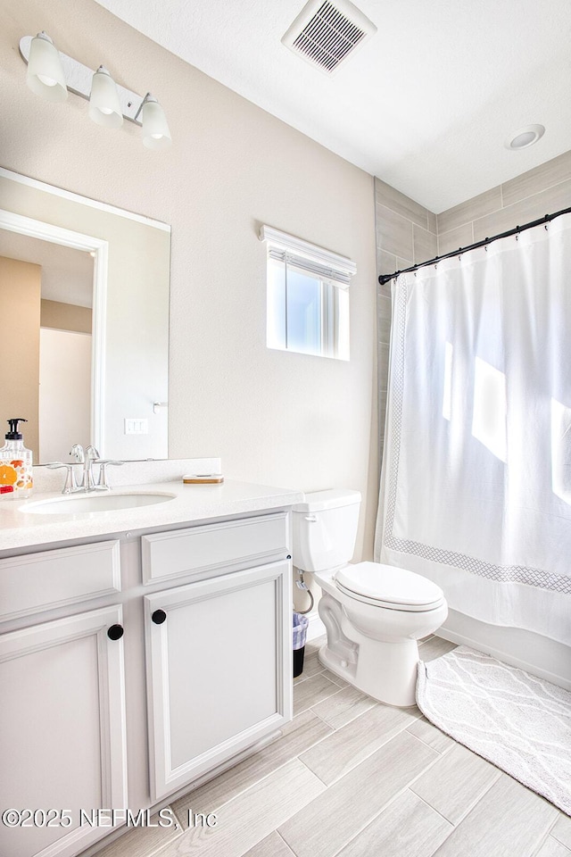 bathroom featuring vanity, curtained shower, and toilet