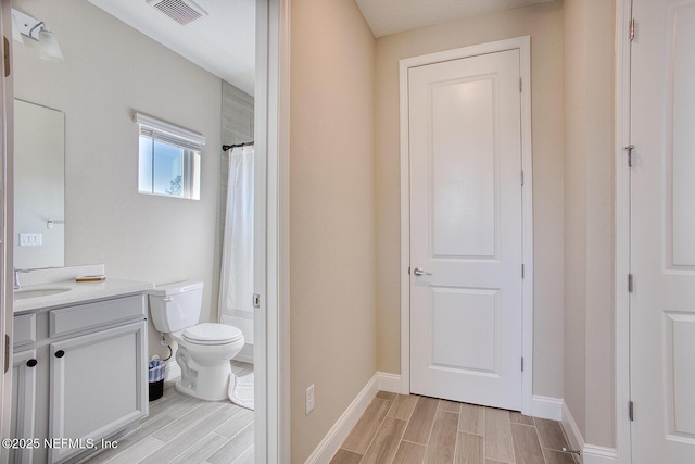 bathroom featuring walk in shower, vanity, and toilet