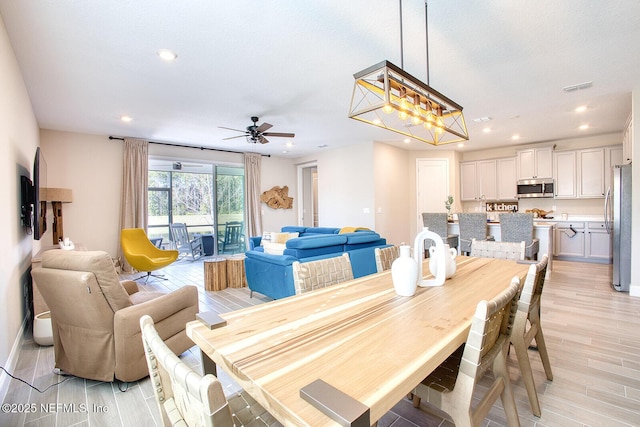 dining room with ceiling fan and light hardwood / wood-style flooring